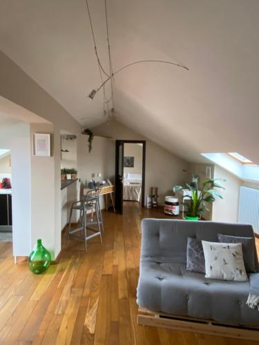 a living room with a couch and a kitchen at La casetta sui tetti in Alba