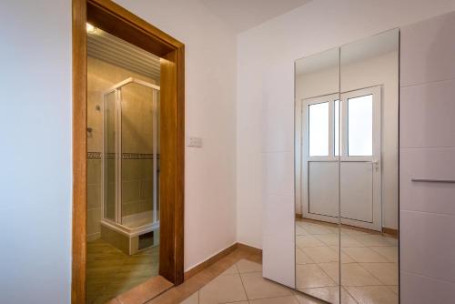 a bathroom with a walk in shower and a glass door at Mango Apartment Petrovac in Petrovac na Moru