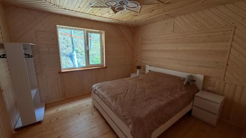 a bedroom with a bed in a wooden room at Mountain House in Vygoda