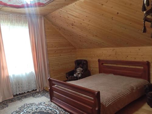 a bedroom with a bed in a wooden ceiling at Caдиба Ксенія in Sheshory