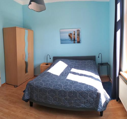 a bedroom with a bed with a blue wall at Ferienwohnung am Dom in Verden