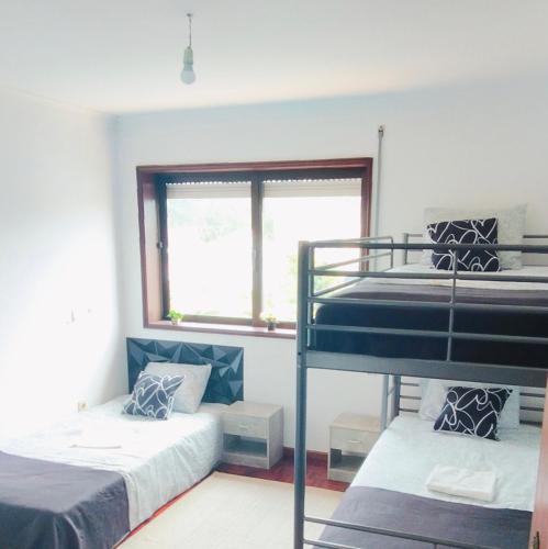 a bedroom with two bunk beds and a window at TurisMar Vila do Conde in Macieiro da Maia