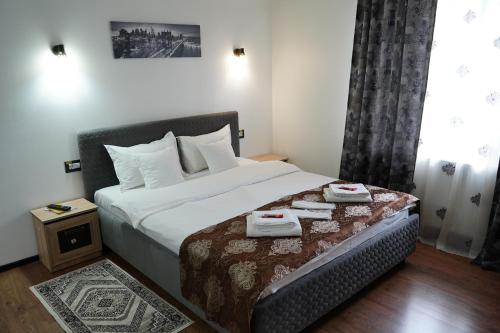 a bedroom with a bed with two towels on it at Casa de la Nuc in Târgu Jiu