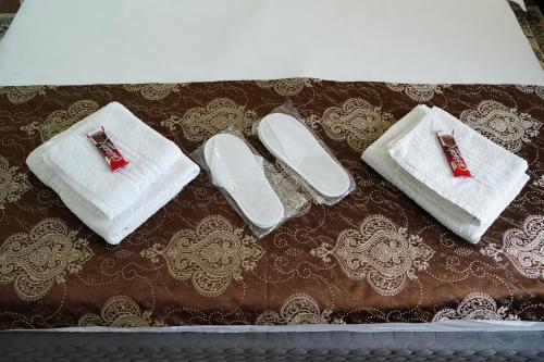 a group of white towels and slippers on a table at Casa de la Nuc in Târgu Jiu
