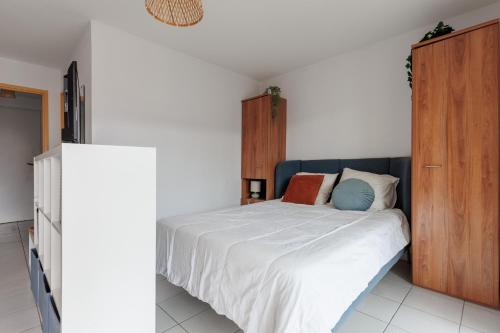 a bedroom with a bed and a wooden cabinet at Aux Gourbets - Conciergerieland in Vieux-Boucau-les-Bains