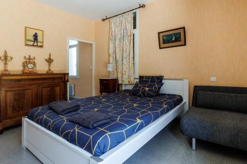 a bedroom with a bed and a chair and a window at Villa Yantet - Conciergerieland in Soustons