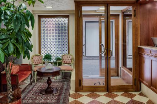 a living room with a glass door and a table at Hotel Commercio & Pellegrino in Venice