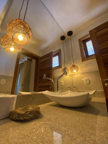 a bathroom with two sinks and lights on a counter at Casa Ilhéus Pousada in Ilhéus