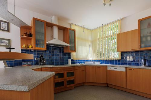 a kitchen with wooden cabinets and a large window at Villa Yantet - Conciergerieland in Soustons