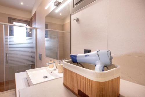 a hairdryer sitting on a counter in a bathroom at Aelion Airport Residence By SEM in Artemida