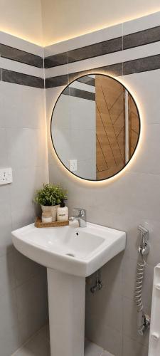 a bathroom with a white sink and a mirror at Nuellas Haven in Kira