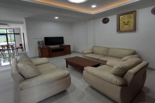 a living room with two couches and a television at Mega Jaya Villa in Yogyakarta
