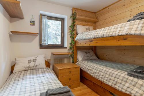 a bedroom with two bunk beds and a window at Relax At The Mountain in Madonna di Campiglio