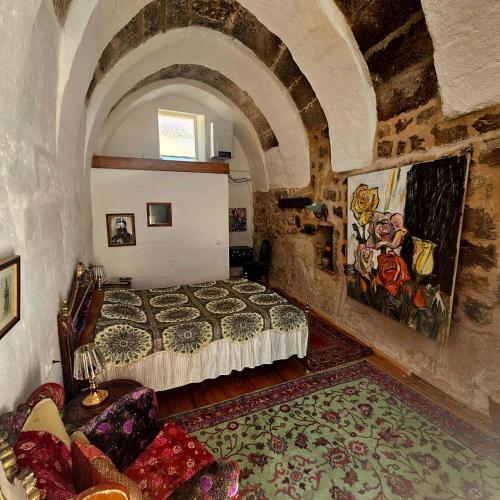 a bedroom with a bed in a stone wall at Dancing Cloud Art House in Uçhisar