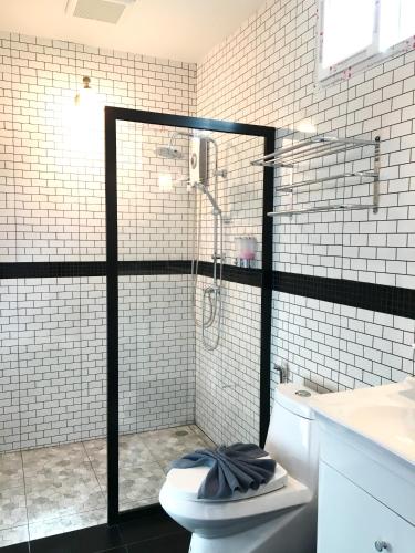 a bathroom with a shower with a toilet and a sink at The Herbal Khao Lak in Khao Lak