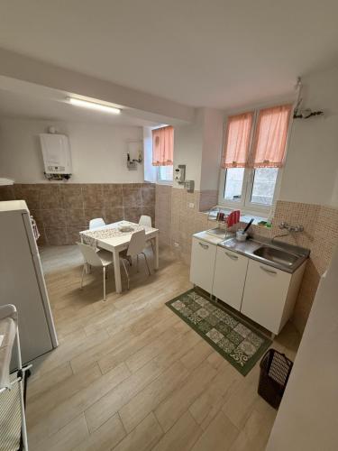 a kitchen and dining room with a table and a sink at Appartamenti La Quiete in Mele
