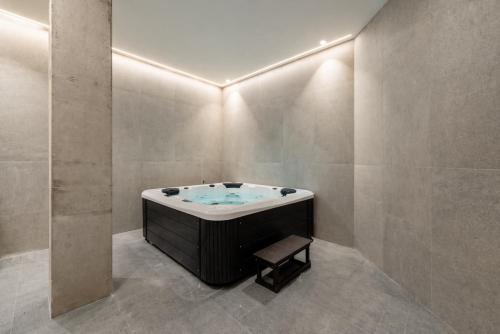 a bathroom with a bath tub with a stool in it at Apartamentos 2H LIVING in León