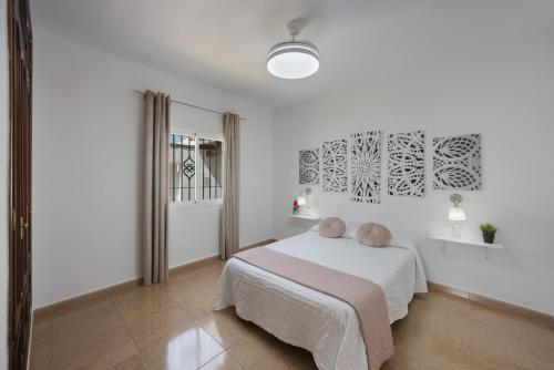 a white bedroom with a bed and a window at Casa Familiar La Lobita 2 in Conil de la Frontera