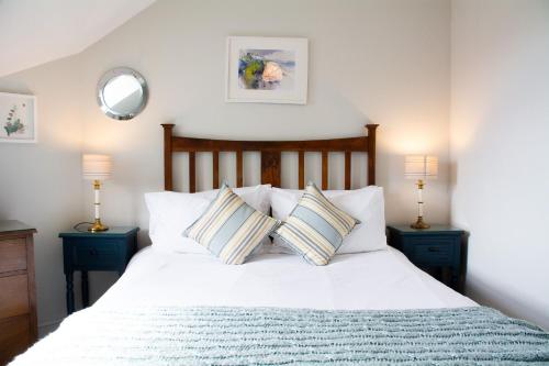 a bedroom with a white bed with two pillows at Ty Haf in Rhosneigr