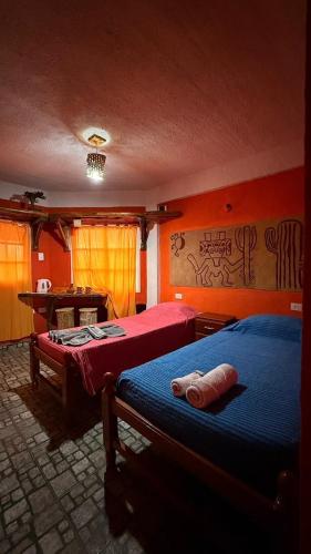 a bedroom with two beds and a table in it at Maité Hospedaje in Santa María