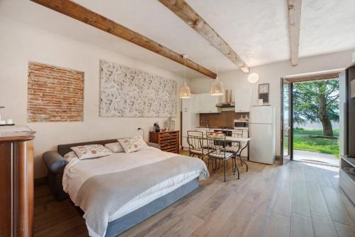 a bedroom with a bed and a kitchen with a table at Cascina Brignolo - Casa Bianca in Novara