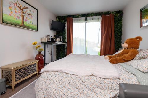 a teddy bear sitting on a bed in a bedroom at Sensori Nuit in Grand-Champ