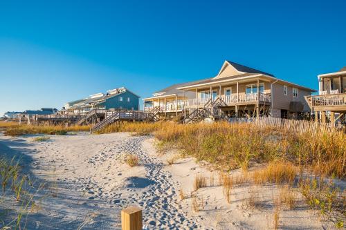a row of houses on a beach next to a beach at Lady Dune in Oak Island