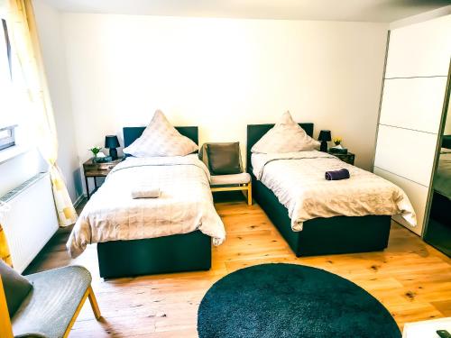 a bedroom with two beds and a green rug at My FeWo in Germersheim
