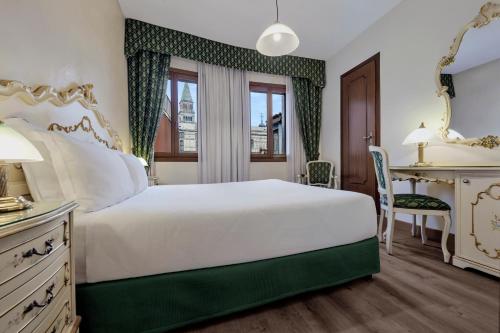 a bedroom with a white bed and a desk at Hotel Commercio & Pellegrino in Venice