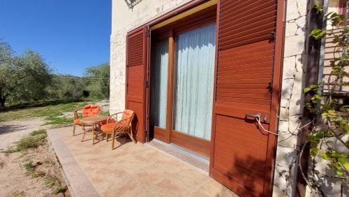 a wooden door with a table and chairs on a patio at Residence degli ulivi in Ossi