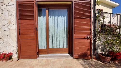 a wooden door on a house with flowers at Residence degli ulivi in Ossi