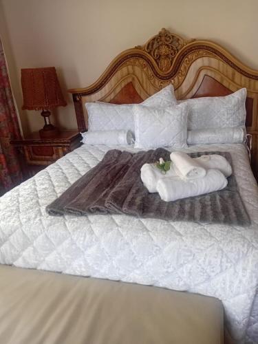 a white bed with two towels and two stuffed animals on it at Executive B & B in Beacon Bay