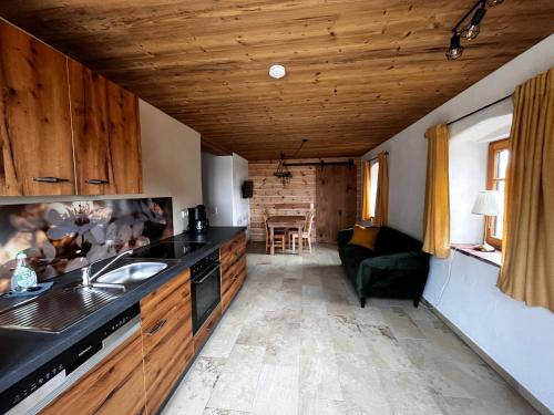 a kitchen with a sink and a couch in a room at Ferienhof Forstmoar in Gars am Inn