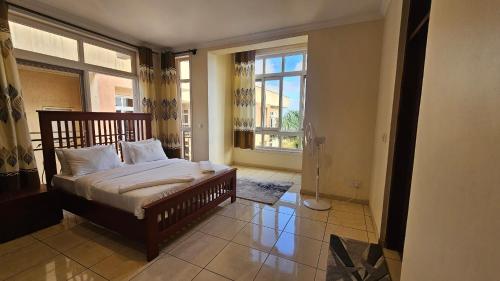 a bedroom with a bed and a large window at JJ Comfort Homes in Arusha