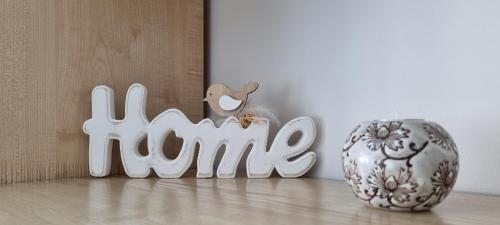 a white sign that says kids next to a vase at Santariškės Apartment in Vilnius