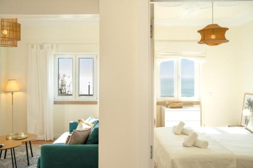 a bedroom with a bed and a blue couch at Horizonte Azul - New Renovated with Sea View in Nazaré