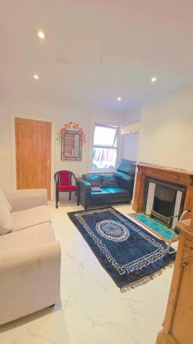 a living room with a couch and a fireplace at Glory room ensuite in Slough