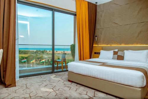 ein Hotelzimmer mit einem Bett und einem großen Fenster in der Unterkunft Bio Hôtel in Lomé