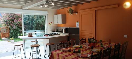 a kitchen with a table with chairs and a counter at Aux 10 Ponts Maison spacieuse et conviviale au bord de la Somme la mer à 30 min 6 personnes in Pont-Rémy