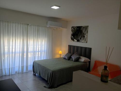 a bedroom with a bed and a large window at APARMENT Paraguay 341 in Rosario