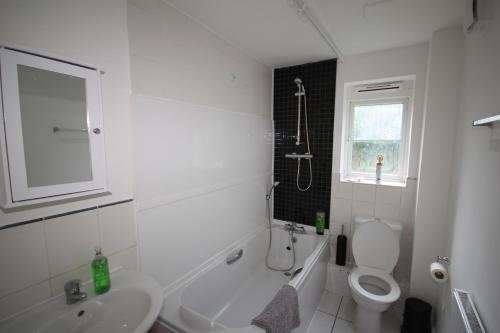 a white bathroom with a sink and a toilet at Bath Road Place in Harmondsworth