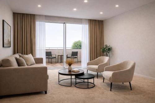 a living room with a couch and chairs and a table at Elitis House - Suite & Spa in Nova Milanese