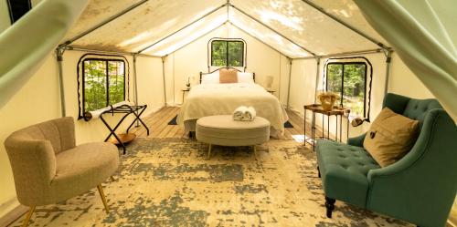 a bedroom with a bed and two chairs in a tent at Naturluxe & Stars in Watkins Glen