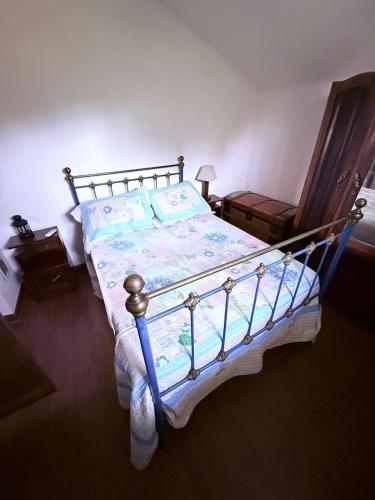 a bed with a blue and white comforter on it at Refugio da Maceira in Marvão