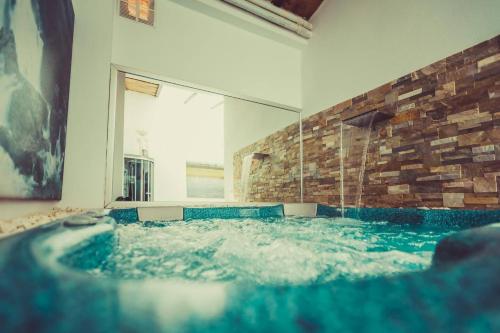 a jacuzzi tub in a room with a stone wall at Casa&Spa Don Gonzalo in Hoya-Gonzalo