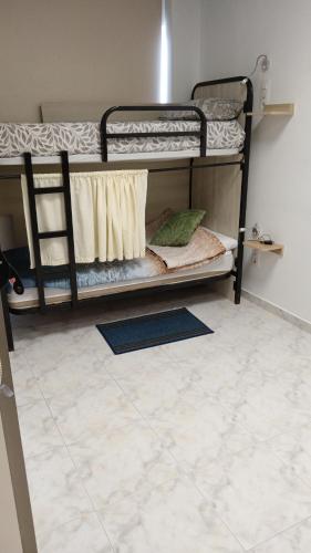 two bunk beds in a room with a tile floor at km24 ALBERGUE in Padrón