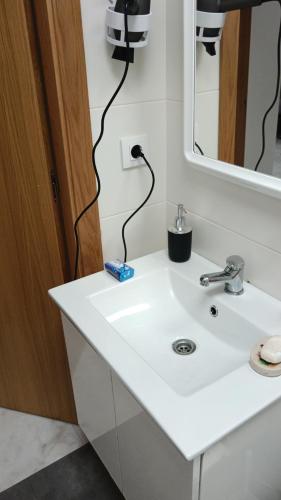 a bathroom with a white sink and a mirror at km24 ALBERGUE in Padrón