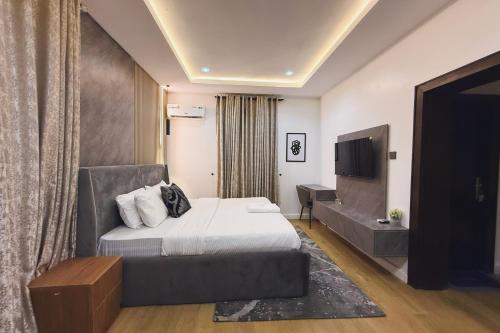 a hotel room with a bed and a television at Macdestly Apartments in Abuja