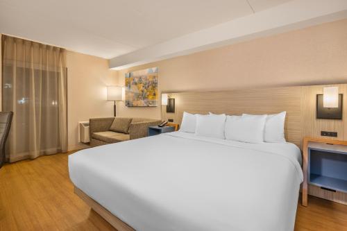 a large white bed in a hotel room at Comfort Inn Alma - Lac-Saint-Jean in Alma