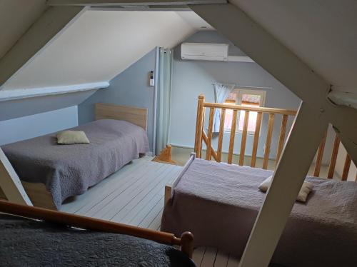 a attic room with two beds and a staircase at GITE "LE VALLON DE PARAY" in Paray-le-Monial
